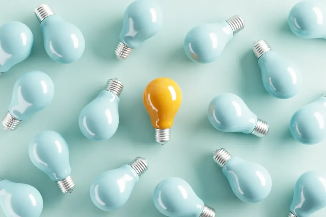 A yellow light bulb among pale bulbs, representing long-term operating insight.